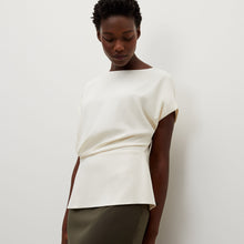 Side image of a woman standing wearing the Nejvi Top in alabaster