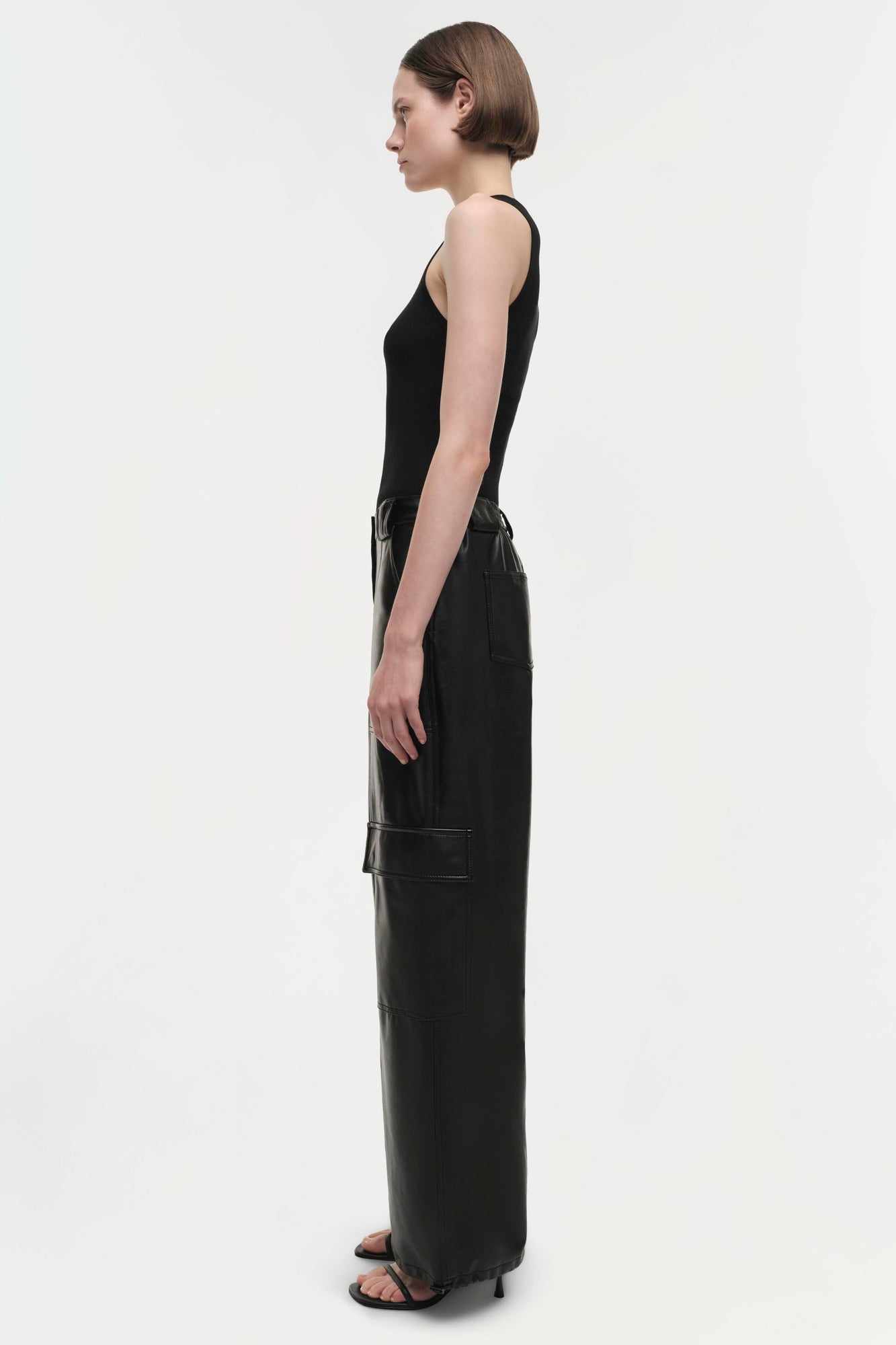 Black cargo pants with multiple pockets, shown on model from side view.