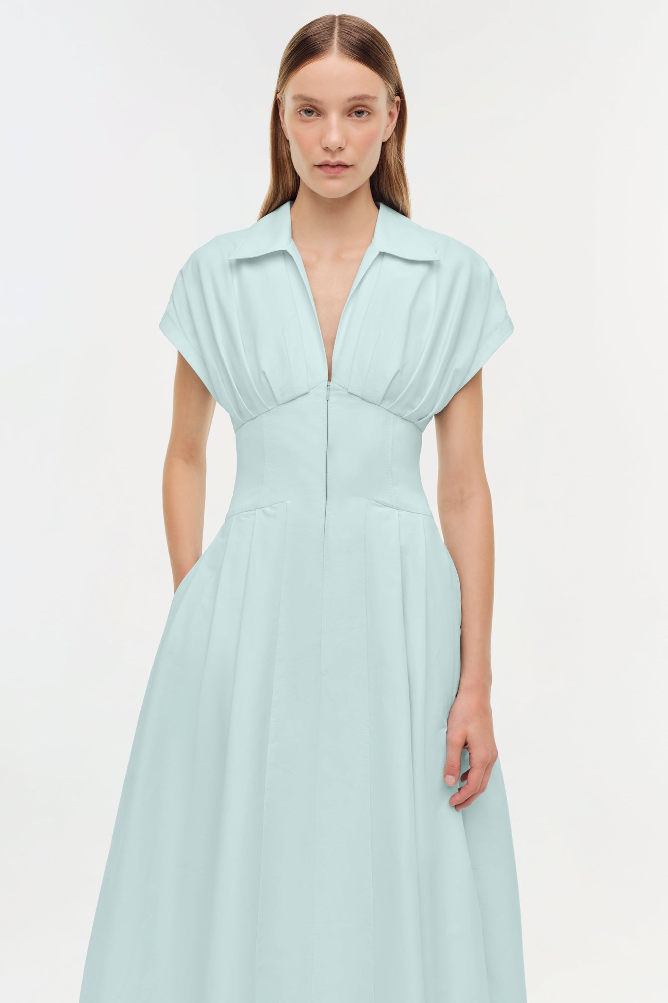 Light blue midi dress with collared neckline, short sleeves, fitted waist, and full skirt with front zip closure.