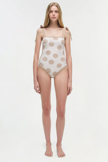 One-piece swimsuit with beige polka dots on white, tie-shoulder straps, and square neckline.
