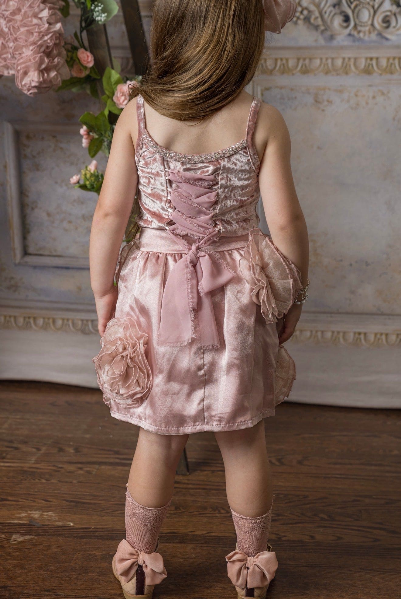 Back view of blush pink girls velvet dress with lace up back and satin bow