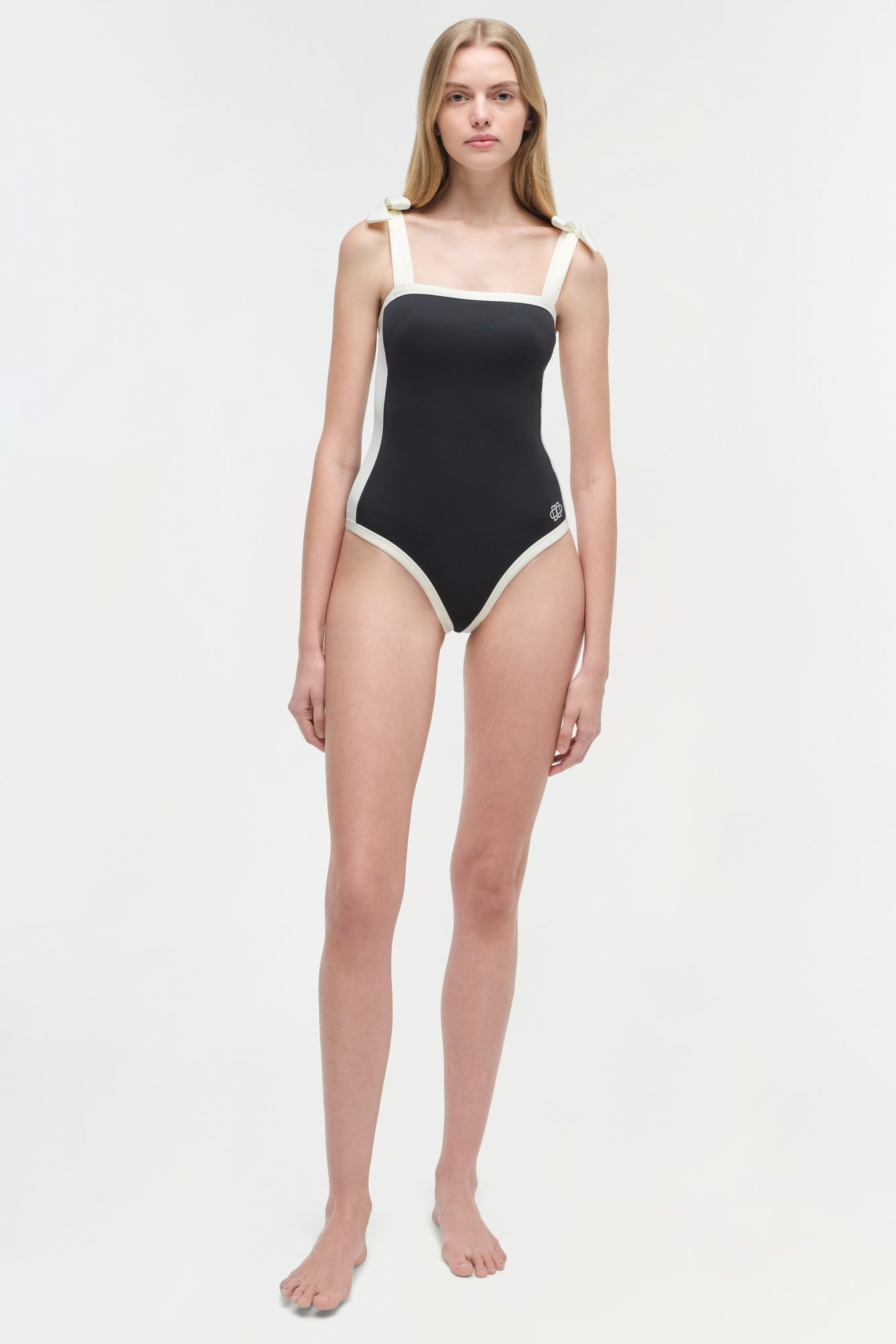 Black and white colorblocked one-piece swimsuit with square neckline and thick shoulder straps.