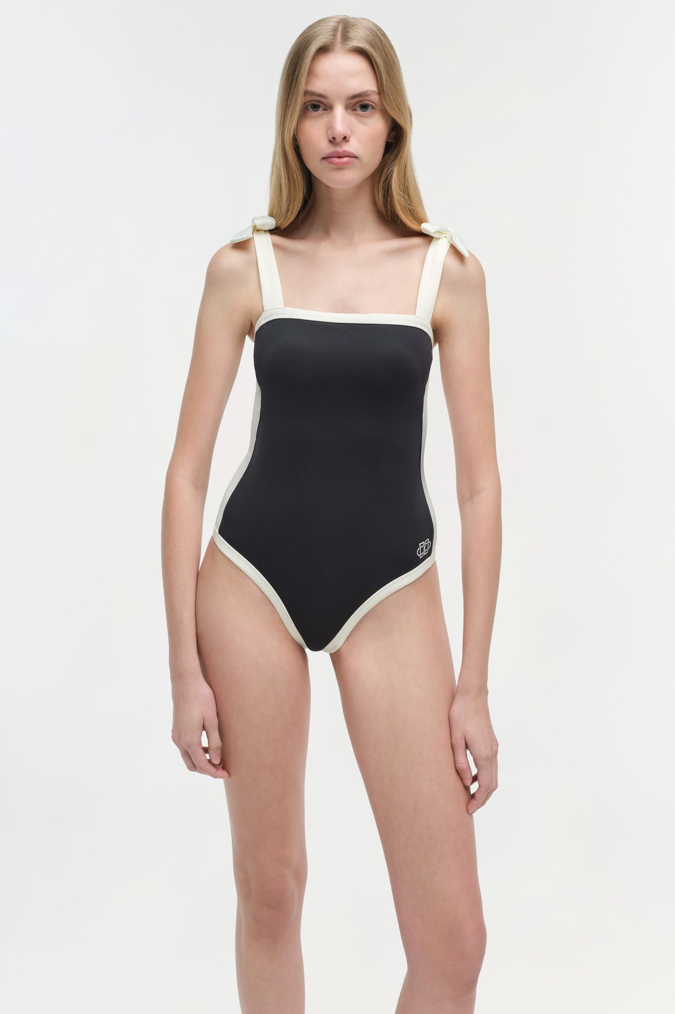 Black and white colorblocked one-piece swimsuit with square neckline and contrast side panels.