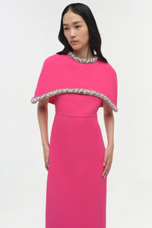 Hot pink gown with a detached cape featuring crystal embellishments at the neckline and cape edge.
