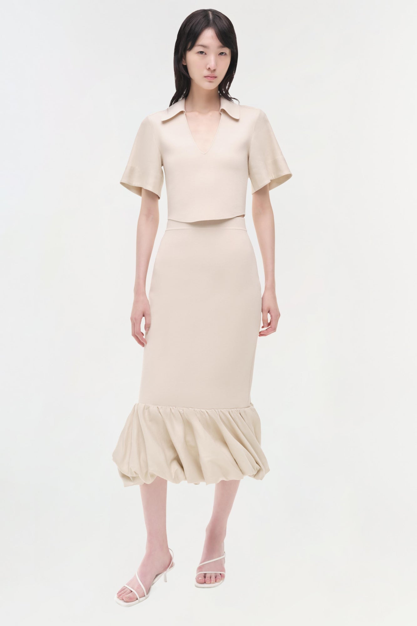 Cream linen knit midi skirt with gathered bubble hem, worn with matching short-sleeve crop top.