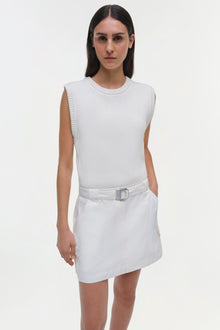 White sleeveless dress with ribbed knit top, white skirt with belt, and cargo pockets.