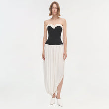 Strapless dress with black sweetheart neckline bodice and white pleated asymmetrical skirt.