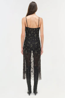 Black lace midi dress with gold embellishments, spaghetti straps, and sheer lace overlay panel, worn with black boots.