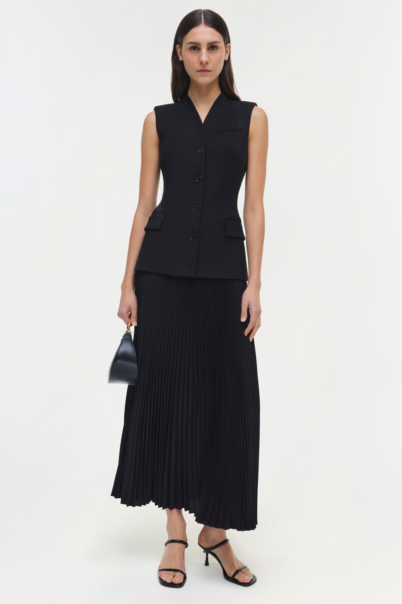 Black sleeveless vest dress with button front and pleated skirt bottom.