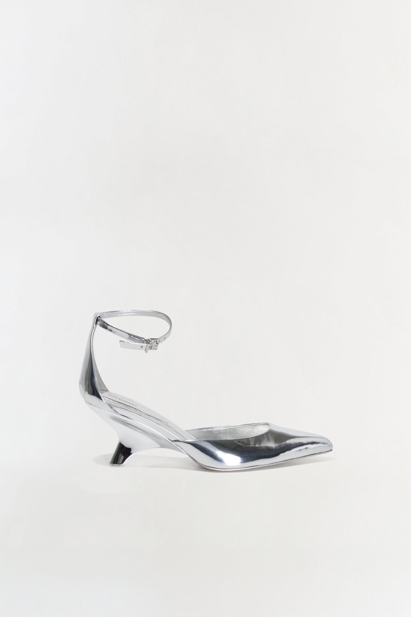 Silver metallic pointed-toe wedge with ankle strap and buckle closure, shown in profile view.