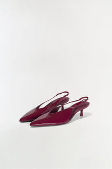 Burgundy patent leather slingback heels with pointed toes and thin kitten heels, shown from a side angle.