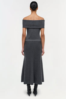 Charcoal wool off-shoulder top with folded neckline and fitted waist, worn with long skirt.