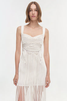 White sleeveless dress with sweetheart neckline, ruched bodice, and pleated skirt with geometric cutout details.