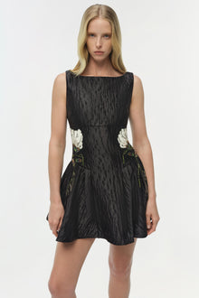 Black jacquard mini dress with white floral embroidery appliquÃ©s at the waist and green leaf embroidery details on the skirt.