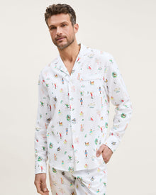 Men's Twill Pajama Set in 12 Days of Christmas: white button-up top and matching pants with a festive print featuring playful animals, palm trees, and people in various poses scattered across the fabric.