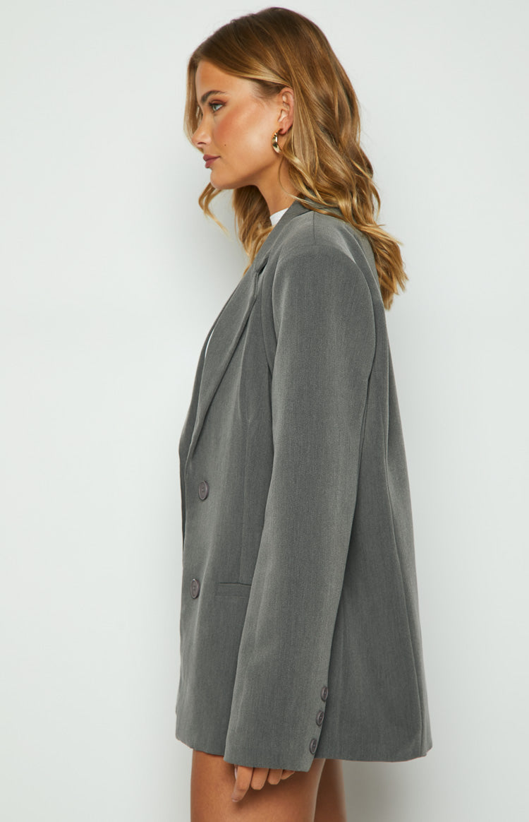 Grey blazer side profile with a relaxed fit, notched lapel, and two buttons on the sleeve cuff