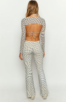 Rear view of cream mesh mid-rise pants with all-over blue star print, fitted through the thigh with flared legs