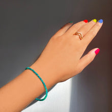 Shimmering beaded bracelet made of smooth opals in shades of bright blue on a gold linking lobster clasp.