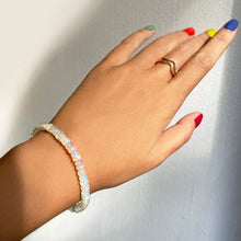 Shimmering beaded bracelet made of faceted opals in shades of milky white and clear on a gold linking lobster clasp.