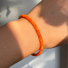 Shimmering beaded bracelet made of faceted opals in shades of orange on a gold linking lobster clasp.