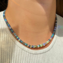 Shimmering beaded necklace made of faceted opals in shades of light blue, light purple, yellow, white, and clear on a gold linking ovals clasp.