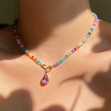 Tie dye opal necklace with an amethyst charm on the neck.