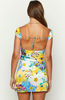 Rear view of the blue floral satin top with a low scoop back, tie closure, and short cap sleeves