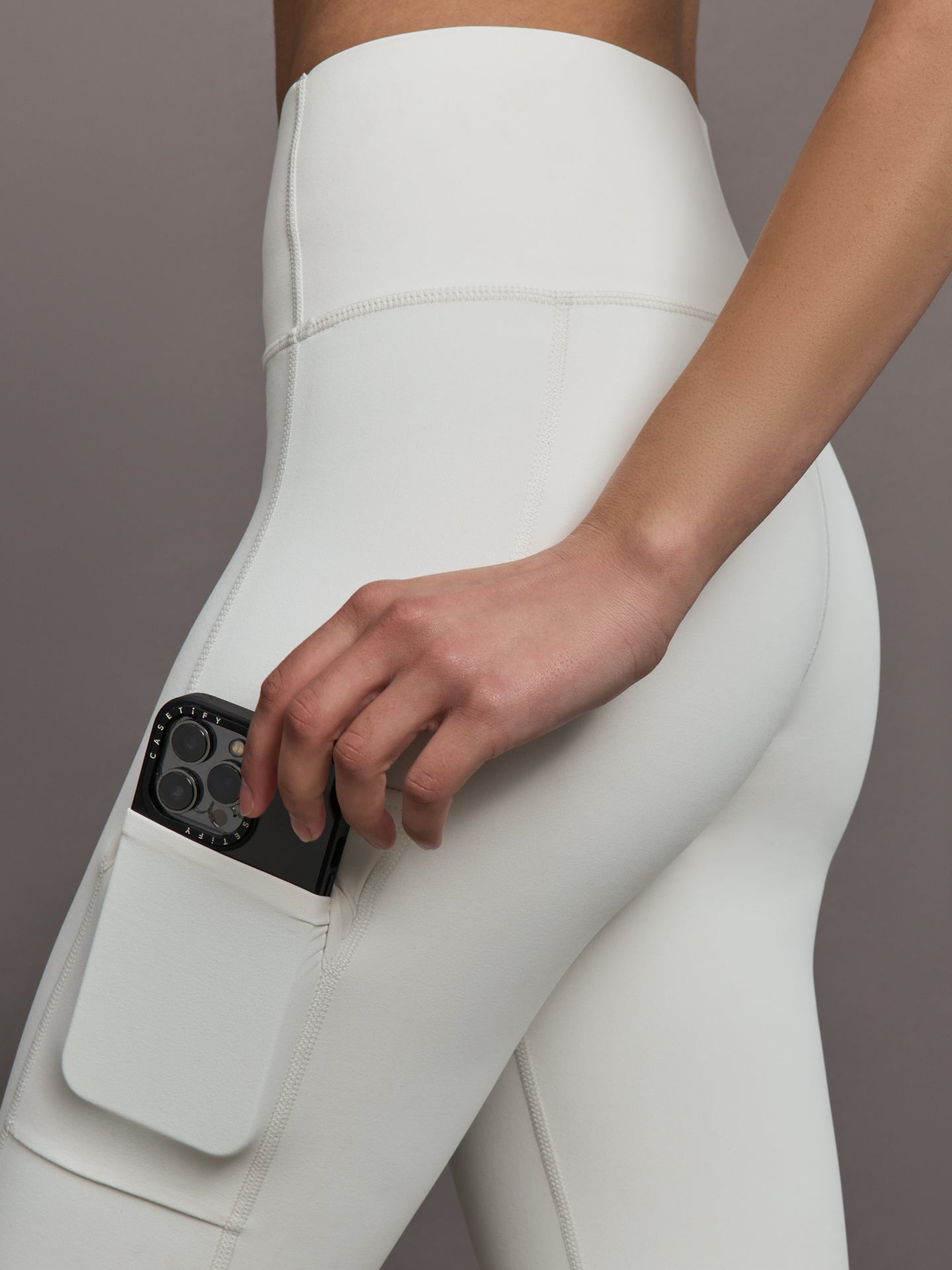 Model wears a highly compressive white high waisted legging with side pocket on outer thigh. 