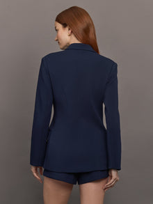 Model wears the Navy double-breasted blazer in Scuba, with a tailored fit, and a smooth, contoured finish.