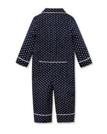 The Baby's Twill Classic Romper in Midnight Hearts is a navy blue onesie with long sleeves and legs, featuring a white heart pattern and white piping on the collar, cuffs, and front.