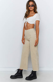 Beige corduroy wide-leg pants with a high waist and frayed cropped hem