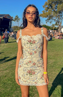 Beige tapestry mini dress with a square neckline, white lace trim, and off-shoulder lace straps