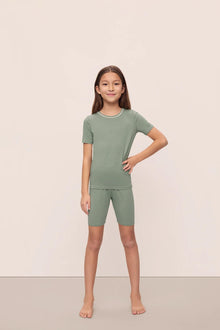 Model is wearing Kids TENCEL Modal Unisex Short PJ Set in Eucalyptus/Ivory