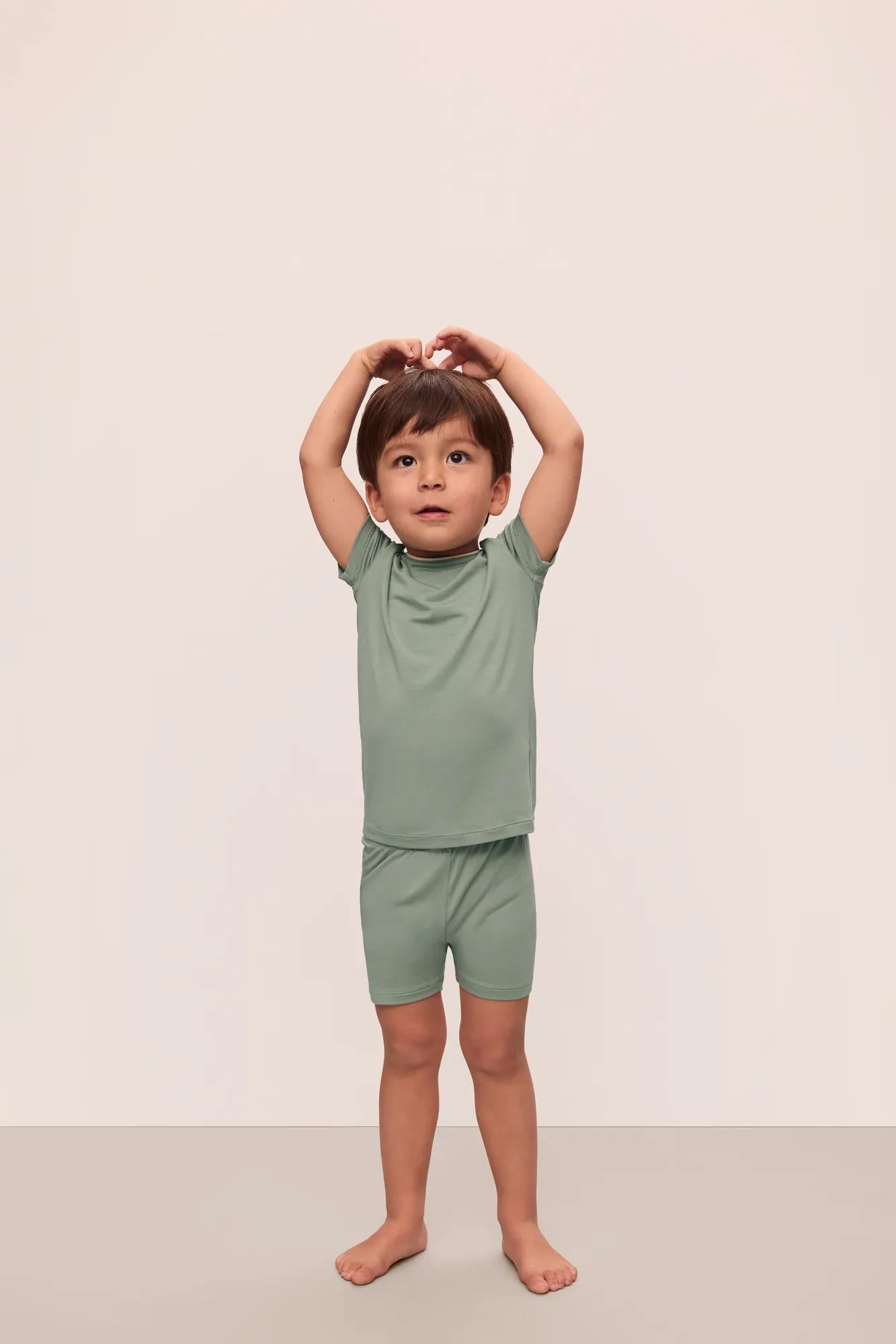 Model is wearing Kids TENCEL Modal Unisex Short PJ Set in Eucalyptus/Ivory