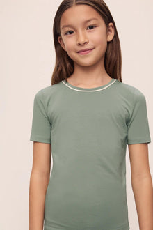 Model is wearing Kids TENCEL Modal Unisex Short PJ Set in Eucalyptus/Ivory