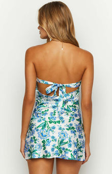 Back view of the white strapless mini dress with blue and green floral print and a self-tie bow closure