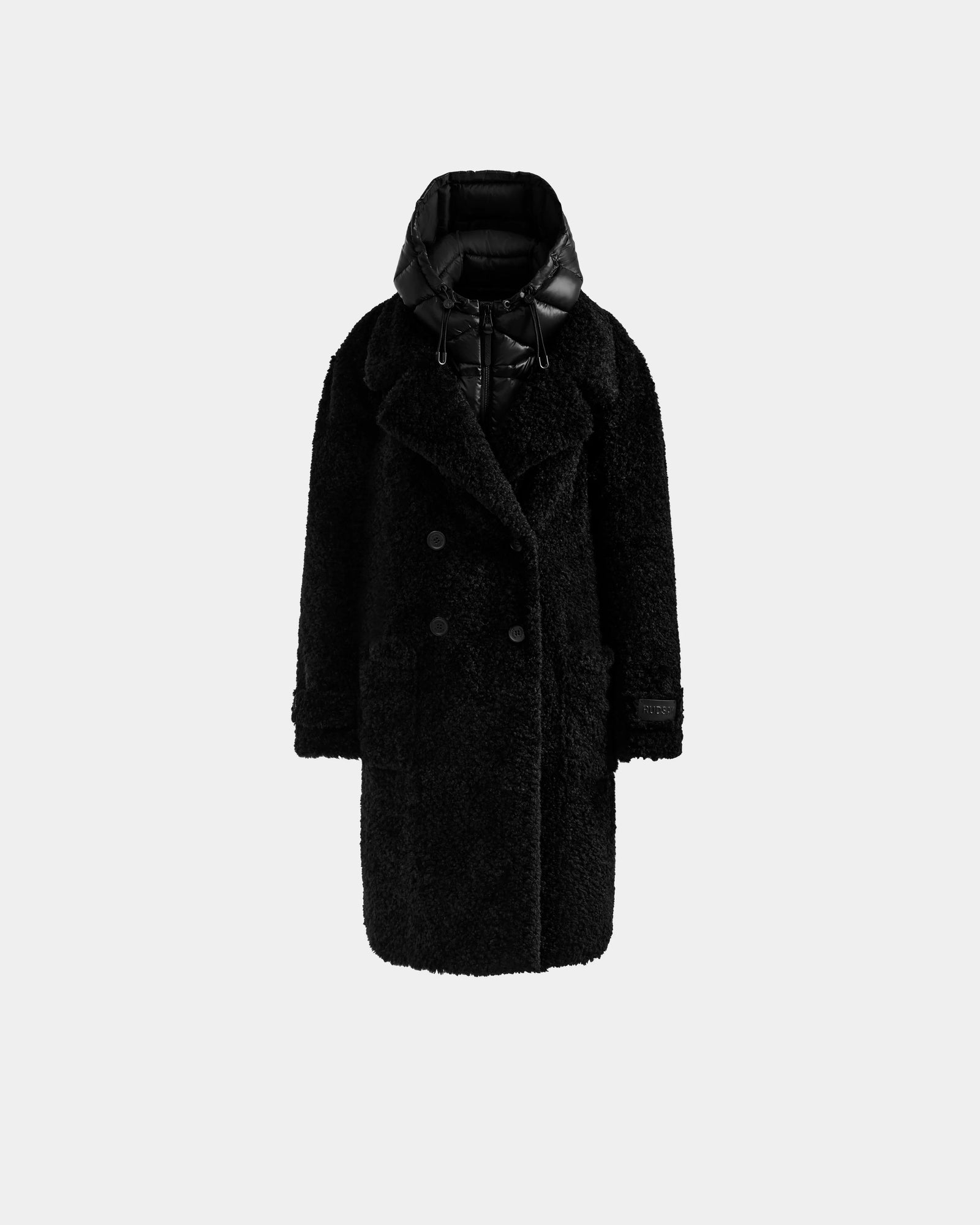 The EMRYN - L125588 Black by Rudsak is a long, black, double-breasted women’s teddy jacket with a textured, fuzzy look and a puffy high-collar hood, shown against a plain light gray background.