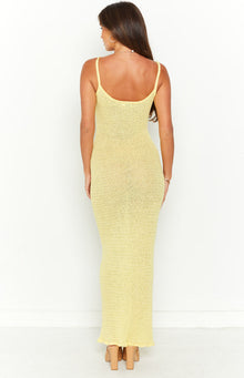 Rear view of a yellow crochet knit maxi dress with a scoop back, thin spaghetti straps, fitted silhouette, and ruffled hem