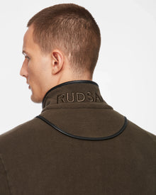 A man with short brown hair is seen from the side and back, wearing the Rudsak ARAGON - 6524539 Army mens fleece full-zip jacket with a standing collar, black vegan leather trims, and Rudsak embroidery—ideal for transitional weather.
