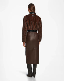 A woman pairs her brown skirt and boots with the chic EVELYN - 8124791 Espresso faux fur jacket by Rudsak.