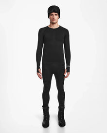 A man stands facing forward wearing the Rudsak FRANC - 6524541 Black fitted men’s thermal set with matching leggings, tall boots, and a black beanie with goggles, posed against a plain white background.