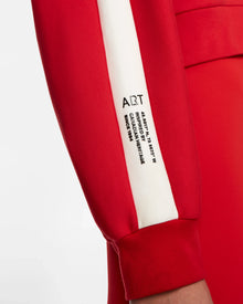 Close-up of a woman wearing the Rudsak KELLIE - 8524615 Flame Red relaxed fit top with a white stripe featuring black ART text and printed details, crafted from comfortable scuba fabric.