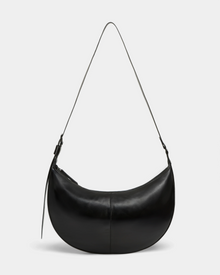 The LANISSA - 8324505 Black by Rudsak is a crescent-shaped black leather hobo bag with a single strap and zipper closure, shown against a plain light gray background.