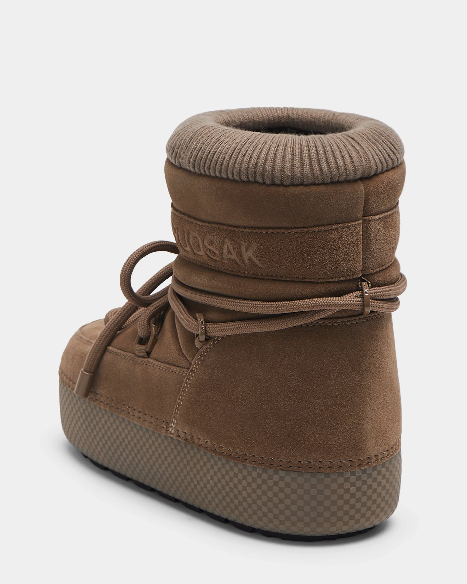 The Rudsak MACE S - 8224543 Camel is a women's short moon boot in brown suede, featuring a thick sole, rounded toe, wraparound laces, padded ankle, ribbed collar, and faux fur lining. Displayed on a white background.