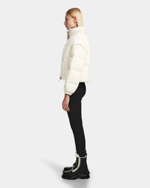 A woman wears the Rudsak OPRAH - 8124708 Iceland womens cropped down puffer, featuring RDS certified ethical down in a crisp white shade.