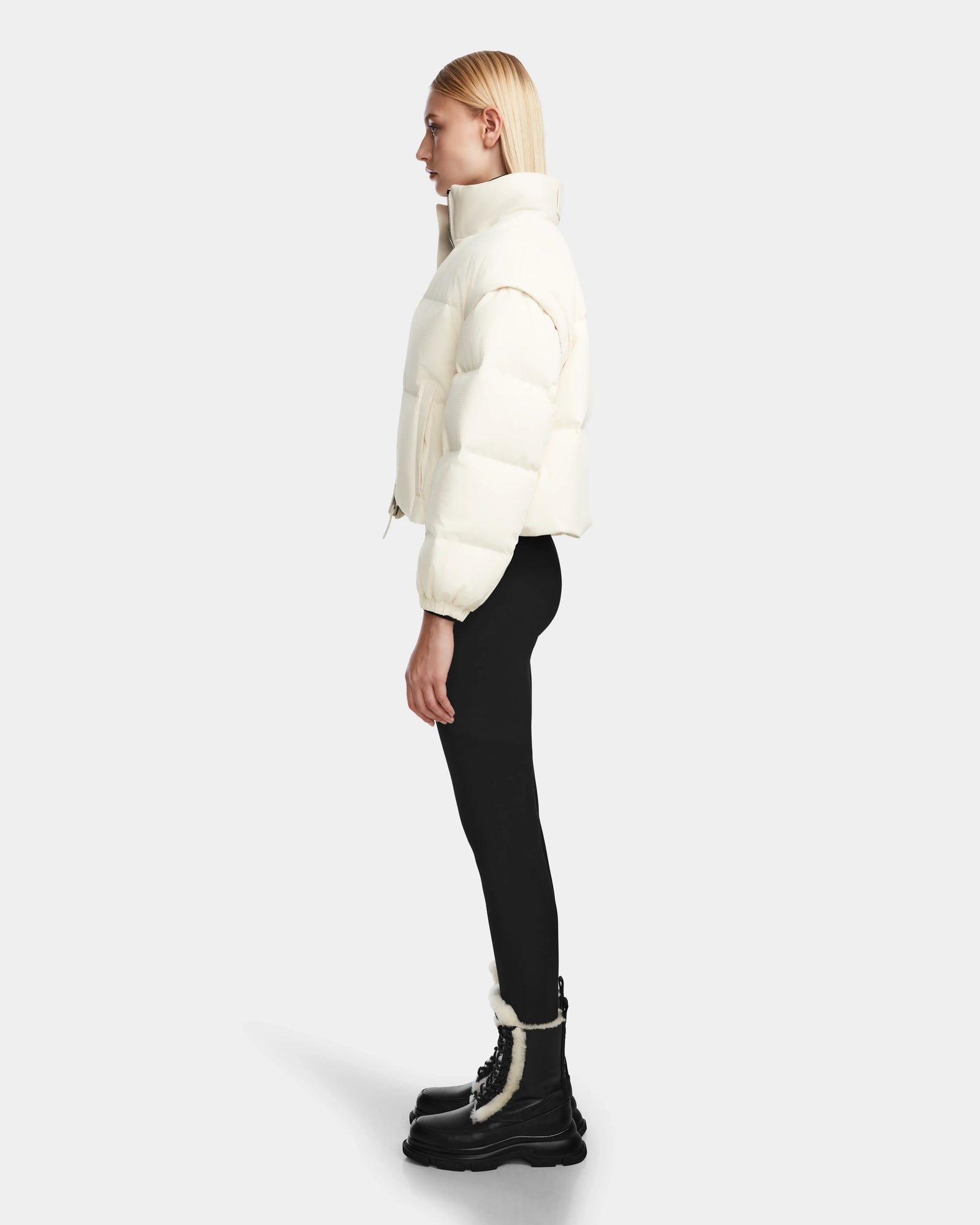 A woman wears the Rudsak OPRAH - 8124708 Iceland womens cropped down puffer, featuring RDS certified ethical down in a crisp white shade.