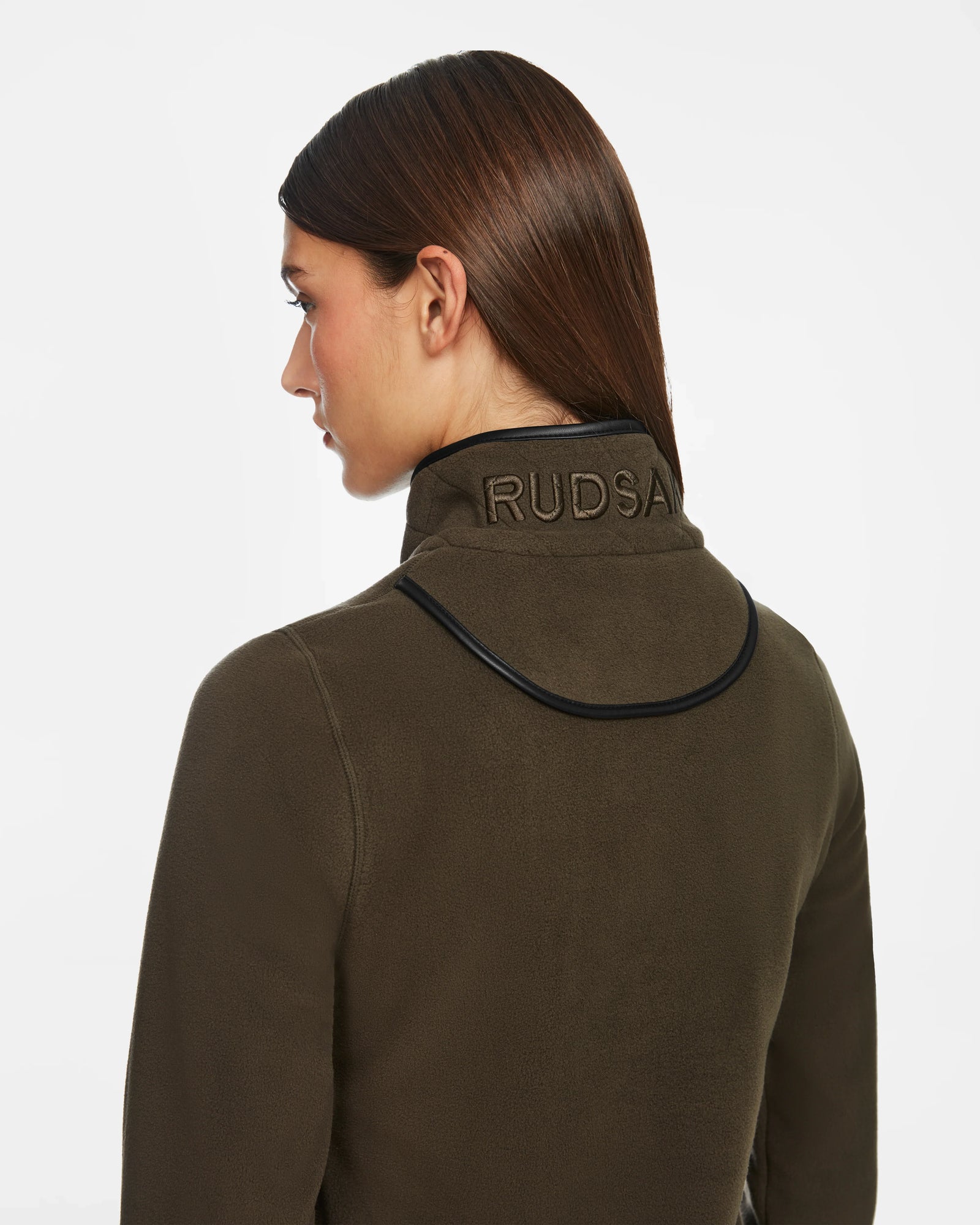 A person with straight brown hair, seen from behind, wears the Rudsak ORCHID - 8524616 Army jacket featuring vegan leather trims and a high collar embroidered with RUDSAK. The background is plain white.