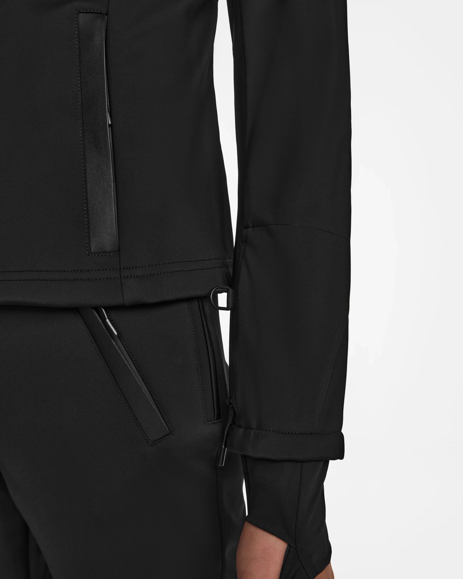 Close-up of the Rudsak ROSALIE - 8124784 Black womens ski jacket and black pants, featuring zippered pockets, a modern tailored fit, and RECCO rescue technology, set against a plain white background.
