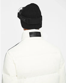 A person is shown from behind wearing a black knit beanie and the Rudsak USHER - 6124516 Optic White winter ski jacket with high collar, featuring RDS-certified down insulation, against a plain white background.