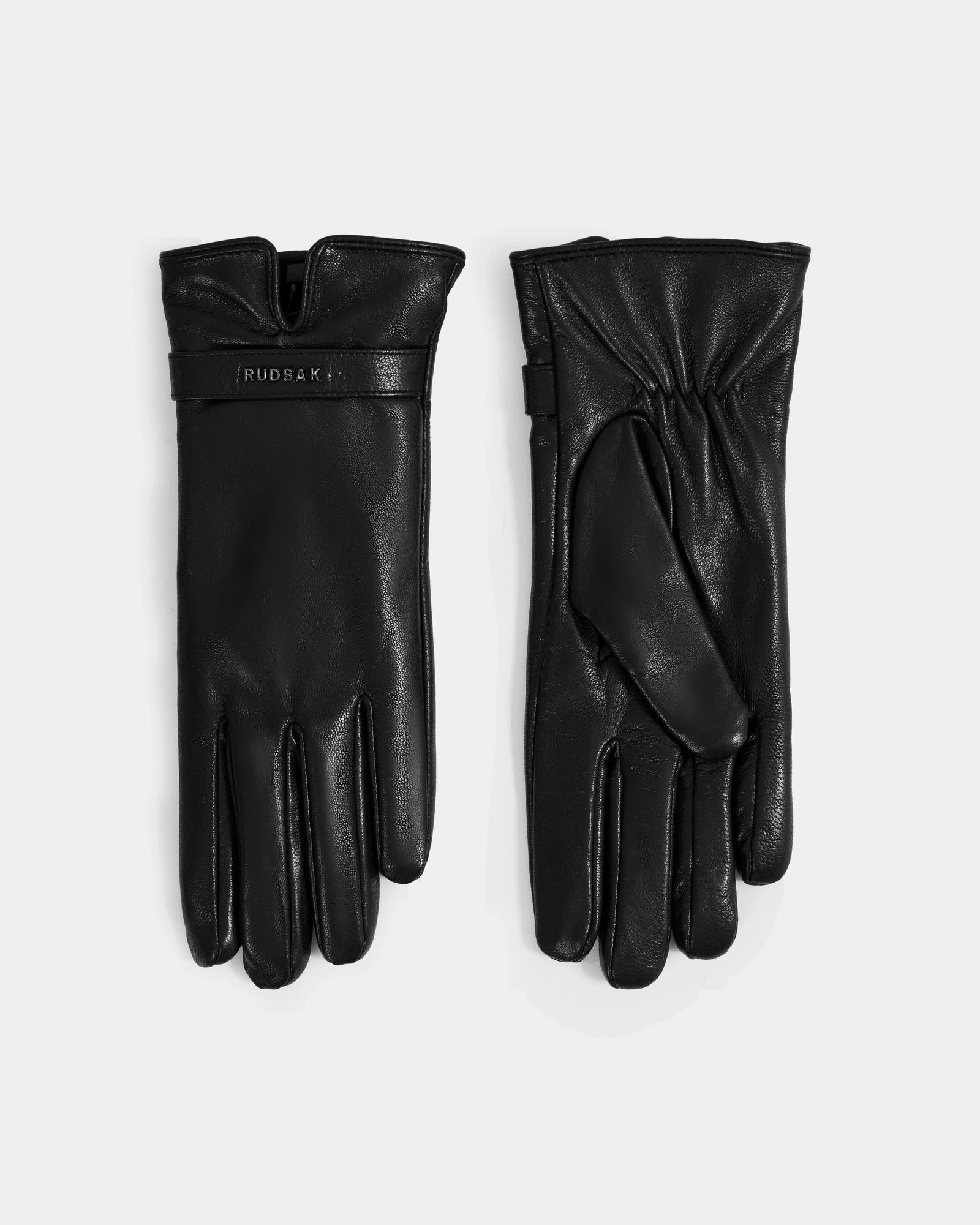 A pair of ALEXIA - L425543 Black women’s leather gloves by Rudsak is displayed on a plain background, one showing the palm and the other the back with a Rudsak logo near the wrist—ideal for cold weather.
